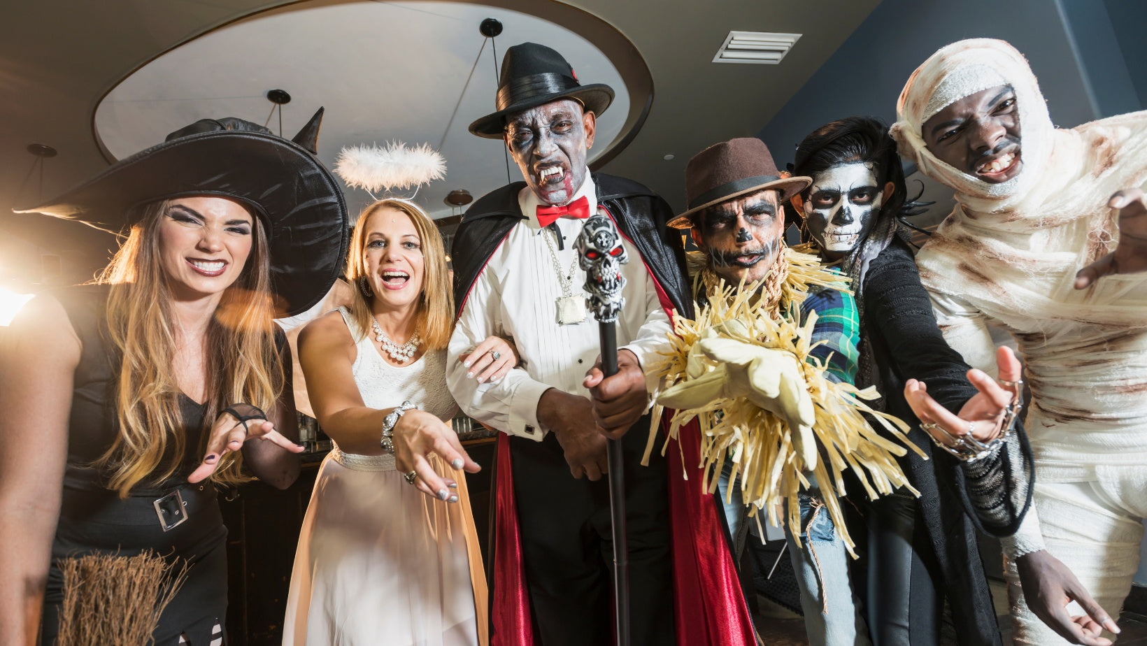 A group of friends dressed up for a murder mystery party having fun and looking at the camera